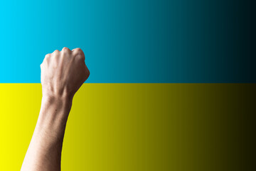 Support for Ukraine and solidarity. Help to the Ukrainian people in wartime. Fists as a symbol of support against the background of the Ukrainian flag. The concept of confrontation and struggle