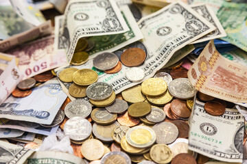 Money from different countries of the world is scattered in a pile of coins and banknotes. American dollars, Romanian lei, Serbian dinars, euro and hryvnia.