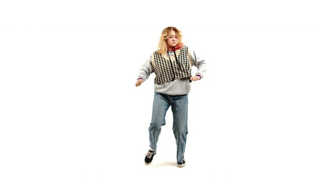Young blonde caucasian girl dance urban style pop hip hop rap a song on infinity white background. her clothes are urban and casual and her hair and clothes move to the sway of the dance.