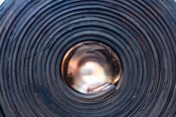 Industrial, new, black rubber twisted into a roll, close-up.