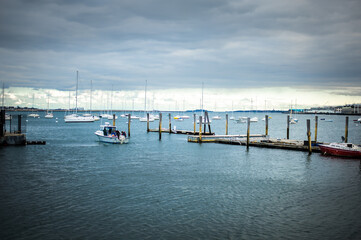 Fototapeta na wymiar wooden pier in the port full of sailing yachts view of the Boston main channel