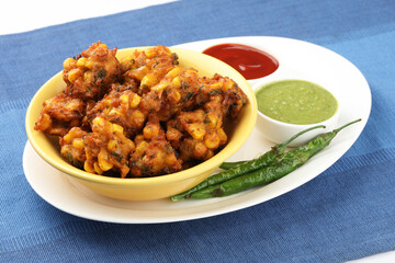 Crispy Corn pakora/pakoda, bhajji, Bhaji, bajji or pattice . served with tomato ketchup & mint chutney