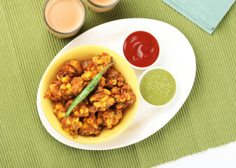Crispy Corn pakora/pakoda, bhajji, Bhaji, bajji or pattice . served with tomato ketchup & mint chutney