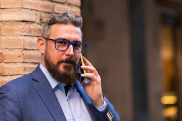 Portrait of adult man looking at camera while talking on phone