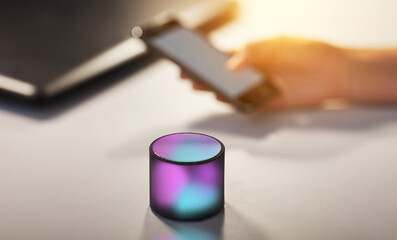 technology concept - glowing smart speaker on table at office