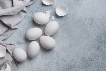 White eggs with eggshells on a concrete table