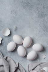 White eggs with eggshells on a concrete table
