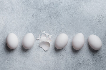 White eggs with eggshells on a concrete table