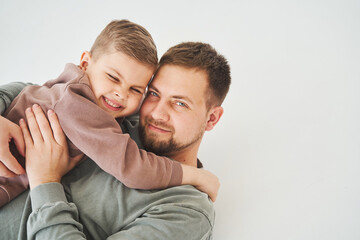 Fototapeta premium Close-up portrait of smiling father and son. Handsome dad and cheerful and emotional kid. Paternity.