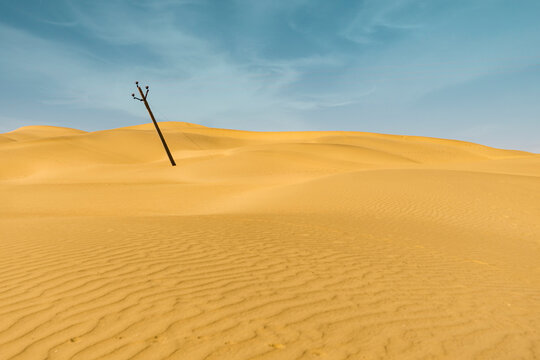 A minimal landscape image of a desert. A electric pole in a desert minimal shot. Minimal landscape concept.