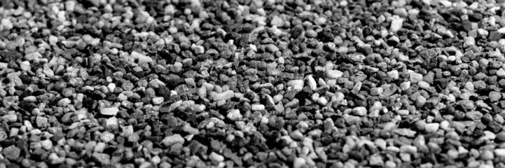 The pattern of small black pebbles stone. Panoramic background
