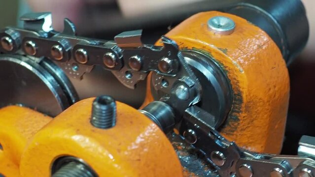 Man rivetes chainsaw chain saw links with riveter. Close-up shot with selective focus