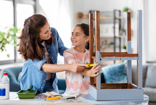 Family, Diy And Home Improvement Concept - Happy Smiling Mother And Daughter With Ruler Measuring Old Wooden Table For Renovation At Home