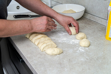 Woman hands preparing slices of dough on a wooden board