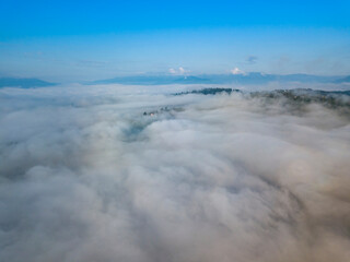 High flight above the clouds in the mountains. Aerial drone view.