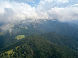 Naklejka premium Green mountains of Ukrainian Carpathians in summer. Sunny day, rare clouds. Aerial drone view.