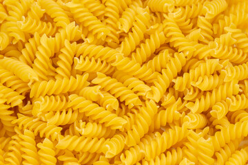 Close-up of raw pasta, texture or background Fusilli. Raw and Dry Macaroni. Italian Culture.