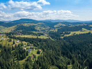 Green mountains of Ukrainian Carpathians in summer. Sunny day, rare clouds. Aerial drone view.