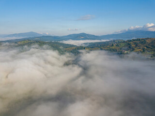 High flight above the clouds in the mountains. Aerial drone view.