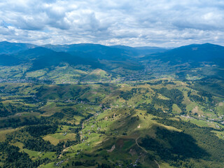 Naklejka premium Green mountains of Ukrainian Carpathians in summer. Coniferous trees on the slopes. Aerial drone view.