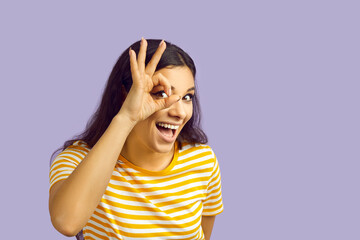 Pleased content excited optimistic woman on lilac purple studio background says Okay, Sure,...