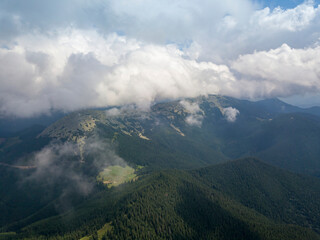 Green mountains of Ukrainian Carpathians in summer. Sunny day, rare clouds. Aerial drone view.