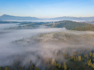 Morning mist in Ukrainian Carpathian mountains. Aerial drone view.