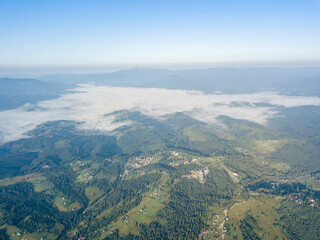 High flight in the mountains of the Ukrainian Carpathians. Fog in the valley. Aerial drone view.