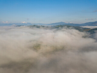 Fototapeta na wymiar High flight above the clouds in the mountains. Aerial drone view.