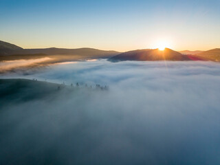 Sunrise over the fog in the Ukrainian Carpathians. Aerial drone view.