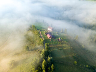 Fototapeta premium Mountain settlement in the Ukrainian Carpathians in the morning mist. Aerial drone view.