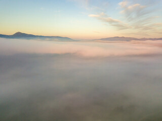 Obraz na płótnie Canvas The rays of dawn over the fog in the Ukrainian Carpathians. Aerial drone view.