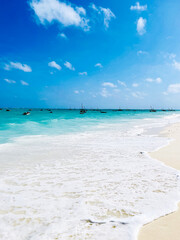 Paradise beach with blue water and boats, Indian Ocean beach in Zanzibar
