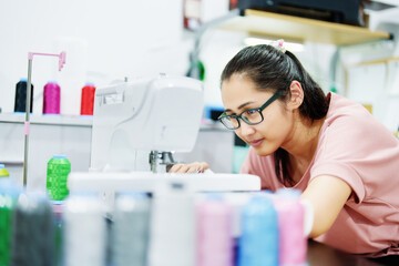 Embroidery, handicrafts, hobbies, SME business, family business, Portrait of Asian female designers are doing by designing patterns using automatic embroidery machines by customer order.