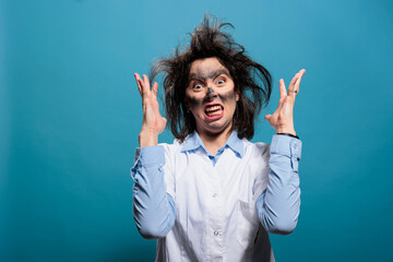 Naklejka premium Mad biochemist with amusing look after laboratory explosion being angry while gesturing with rage. Goofy looking crazy scientist with dirty face and messy hair after failed chemical experiment.