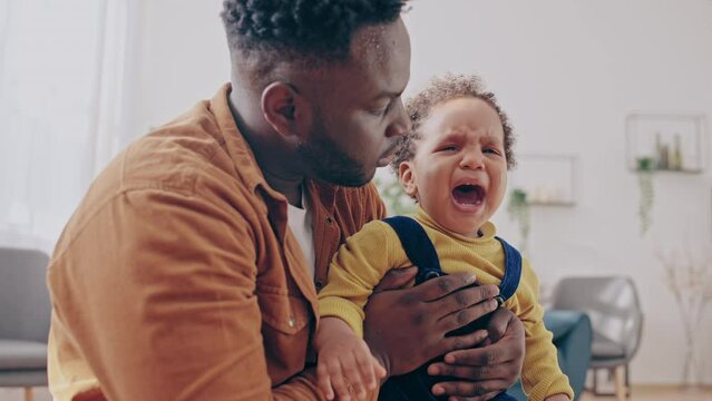 Caring father trying to calm down crying baby-boy, paternity leave, family