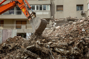 Crane demolition of buildings damaged by the earthquake. Excavator