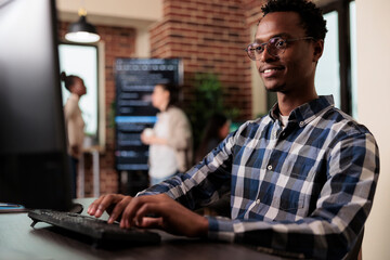 Smiling confident african american software engineer developing machine learning algorithm in order...