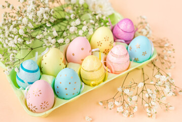 tray with colorful eggs and flowers. Easter background in pastel colors