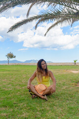 portrait of a latin woman smiling, having fun, on vacation in mallorca posing on a warm spring summer day, under a palm tree, hollidays concept
