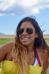 beautiful and happy latin woman with long hair smiling, having a good time, on vacation in mallorca hollidays concept