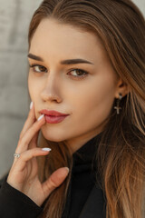 Cute female portrait of a beautiful stylish girl hipster with hairstyle and fashionable clothes on the street