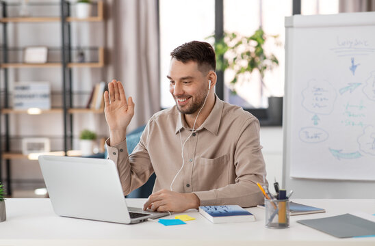 Distant Education, School And Remote Job Concept - Happy Smiling Male Teacher With Laptop Computer And Earphones Having Online Class Or Video Call At Home Office