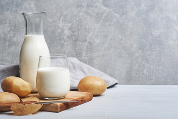Potato milk. Potato milk served in glass bottle on rustic background.