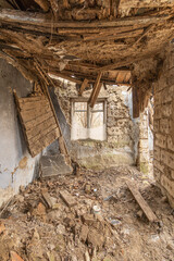 Fototapeta na wymiar Inside an old ruined Ukrainian house with a collapsed roof. Destroyed interior.