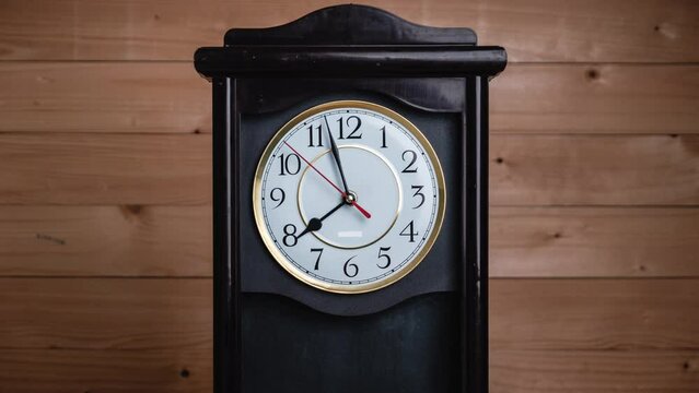 Vintage Clock Arrows Rotate at 8 PM or AM, Full Turn of Time Hands, Timelapse. Old Retro wall clock with second, minute, and hour hands on a white circular dial. An antique clock on wooden background