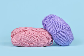 Pink and purple balls of wool on blue background