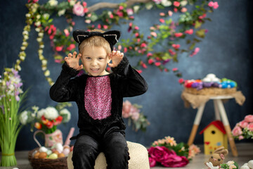 Cute preschool child in cat carnival costume, boy dressed as a black cat on Easter decoration