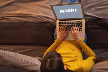 Back view of woman writing on laptop screen the word CV online, working from home, female applicant typing cover letter, applying for job,