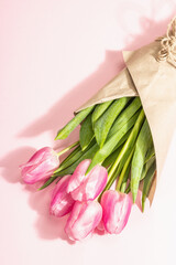 Fresh flower composition, a bouquet of pink tulips, isolated on a rose background